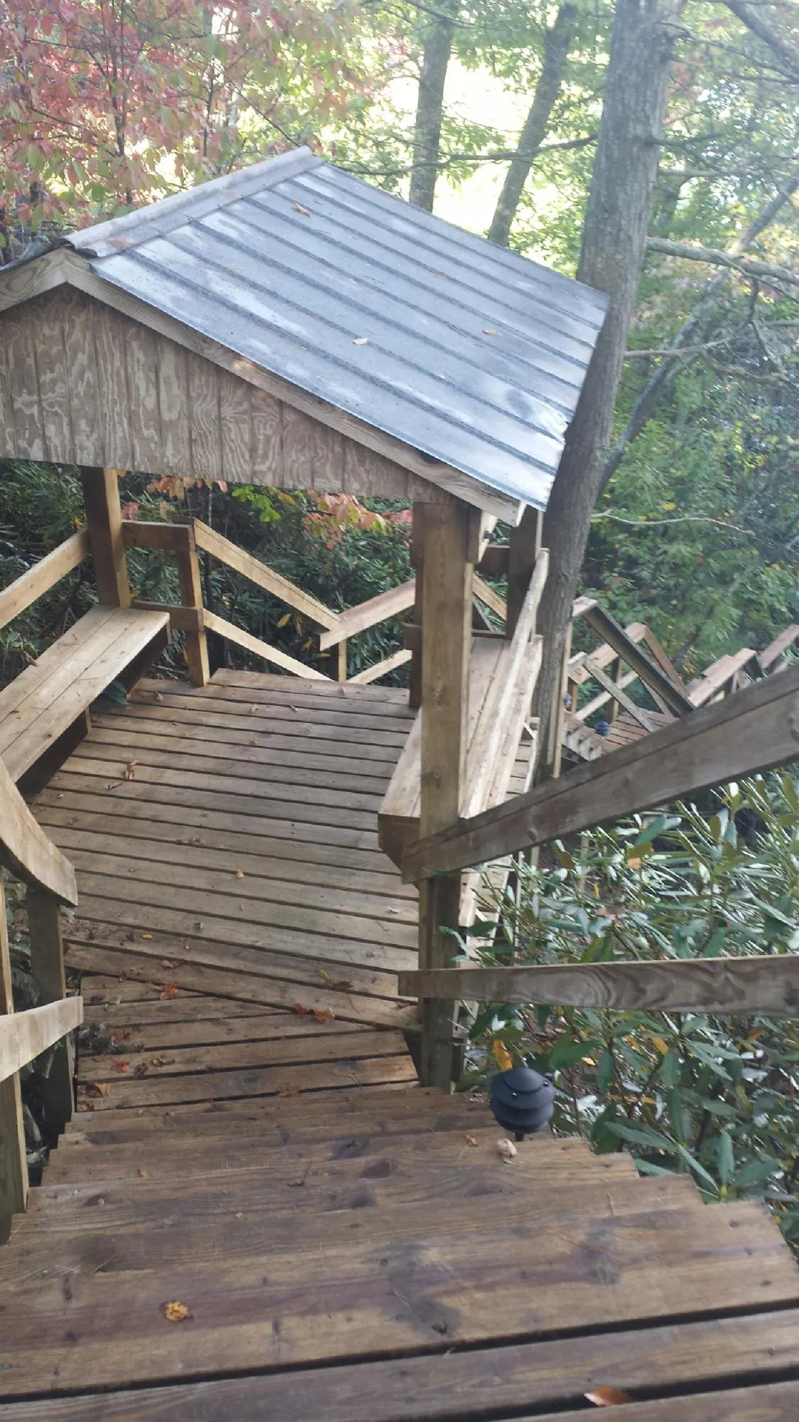 Metal roofed shelter over wooden steps on a wooded walkway — Skylight Repair & Installation work by our crew in New Lothrop