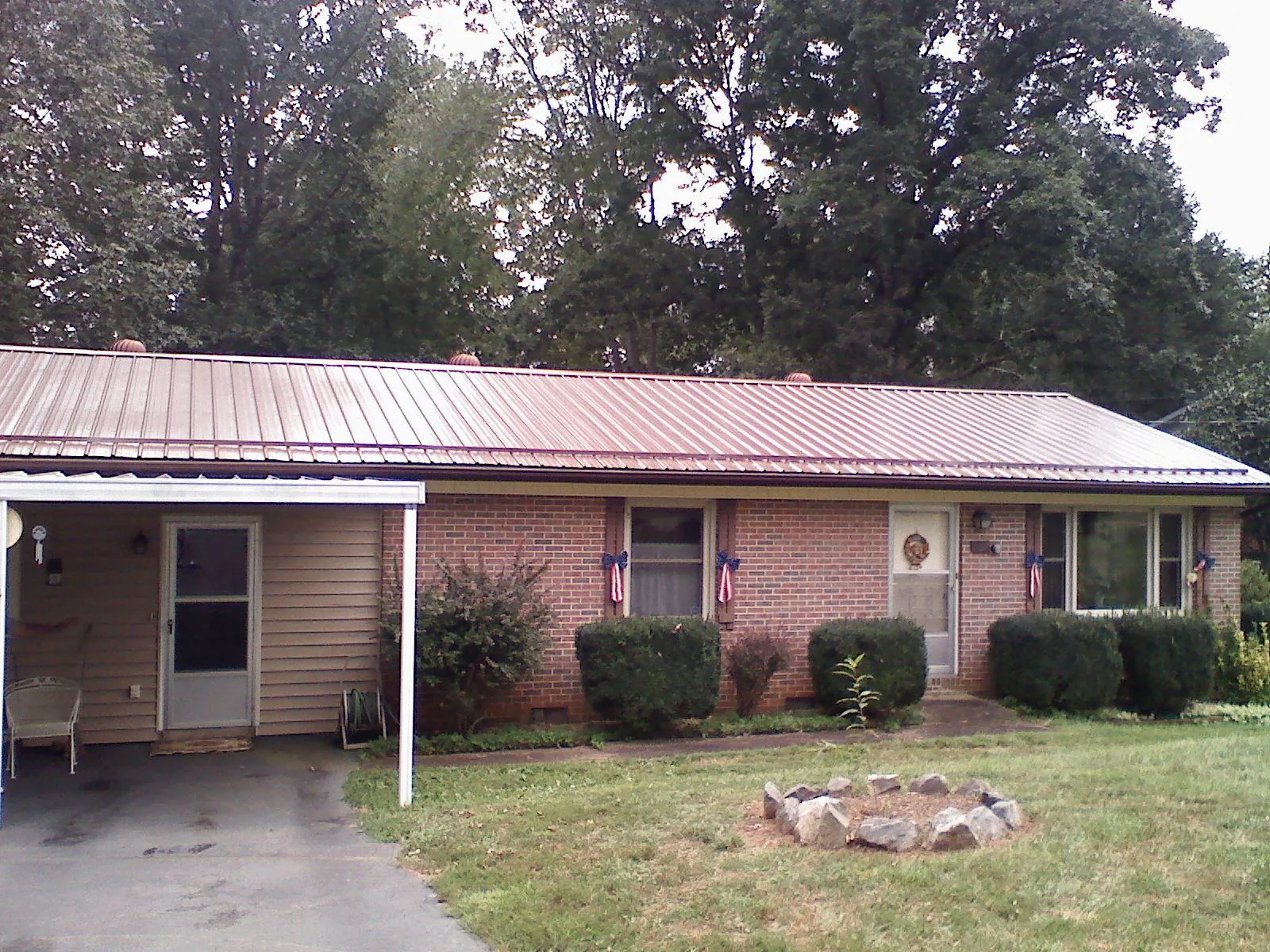 Bronze metal roof and carport on a brick ranch home — Roof Repair work by our crew in New Lothrop